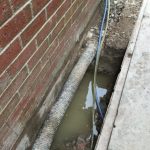 Water ingress into sub-floor void caused by high water table, impermeable sub-soils and defective drainage. In this case the existing land drain has been installed by others many years ago at the incorrect height rendering it ineffective.